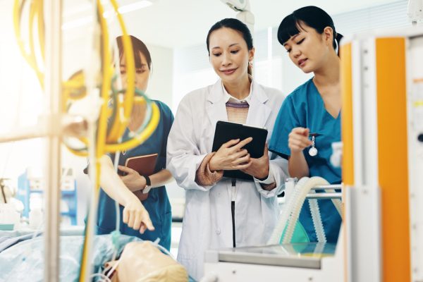 Hospital, doctor and mannequin with healthcare mentor and nursing dummy for anatomy students. Colle.